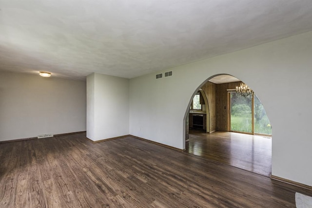 301 Garnett Ave, Winthrop Harbor, IL 60096 - empty room with arched walkways, wood finished floors, a chandelier, and baseboards