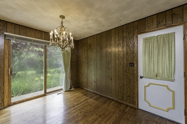 301 Garnett Ave, Winthrop Harbor, IL 60096 - unfurnished dining area featuring a chandelier, wooden walls, and wood finished floors