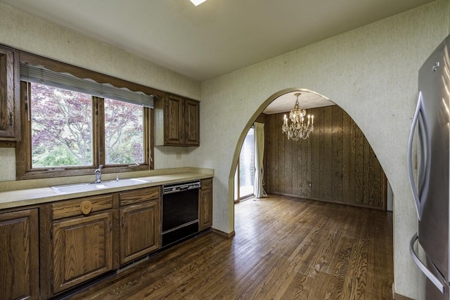 301 Garnett Ave, Winthrop Harbor, IL 60096 - kitchen with black dishwasher, a sink, arched walkways, a chandelier, and dark wood-style floors