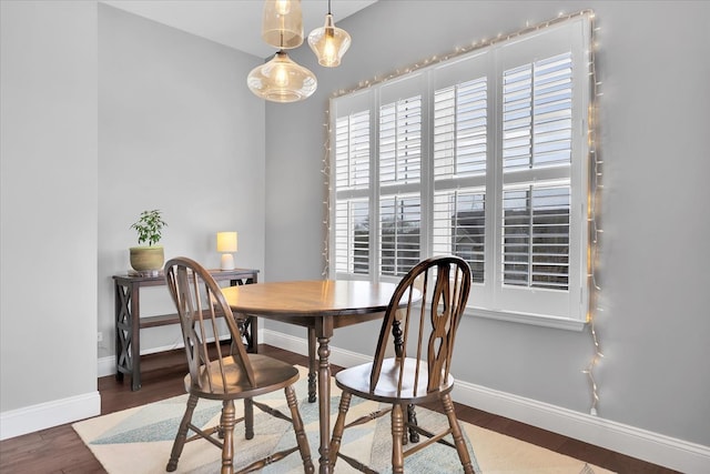 dining area with baseboards and wood finished floors