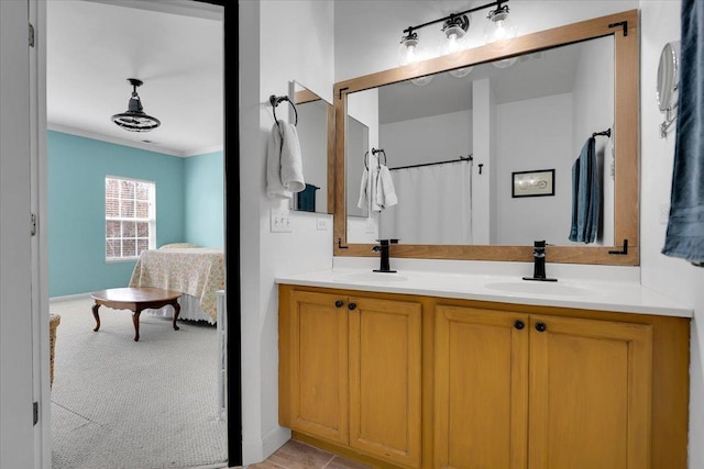 full bathroom featuring a sink, ornamental molding, ensuite bathroom, and double vanity