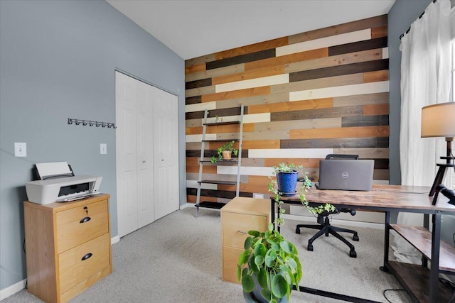 office featuring light colored carpet, wood walls, and baseboards