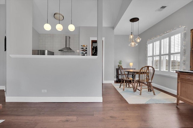 dining area with visible vents, baseboards, and wood finished floors