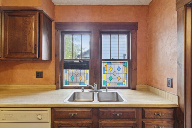 2228 8th St, Rockford, IL 61104 - kitchen featuring a sink, light countertops, white dishwasher, and brown cabinets