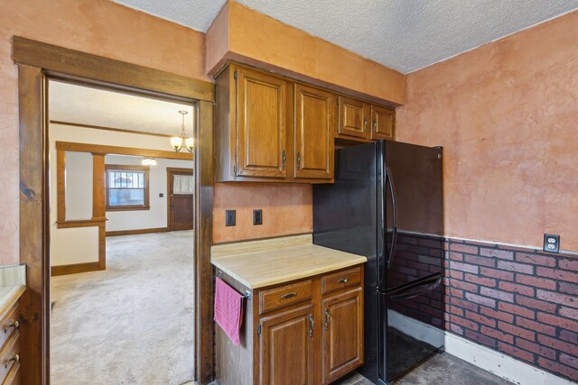 2228 8th St, Rockford, IL 61104 - kitchen with light countertops, freestanding refrigerator, brown cabinets, and a textured ceiling