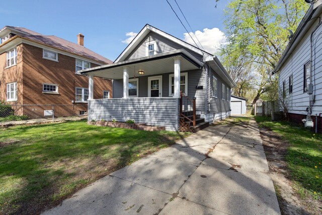 2228 8th St, Rockford, IL 61104 - view of front facade with a porch, a front yard, an outbuilding, a detached garage, and fence