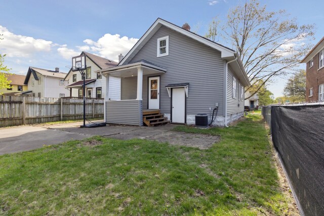 2228 8th St, Rockford, IL 61104 - back of house with fence private yard, a lawn, a chimney, and cooling unit