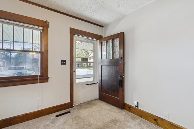 2228 8th St, Rockford, IL 61104 - entryway featuring visible vents, ornamental molding, baseboards, light colored carpet, and a textured ceiling