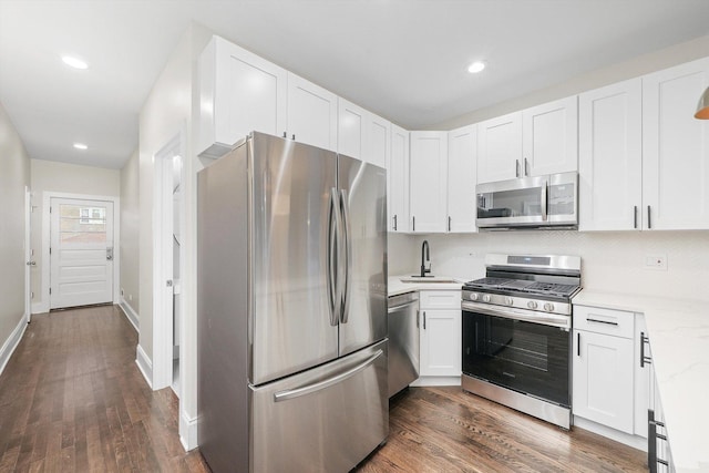4825 W Oakdale Ave, Chicago, IL 60641 - kitchen featuring appliances with stainless steel finishes, a sink, dark wood-type flooring, white cabinets, and recessed lighting