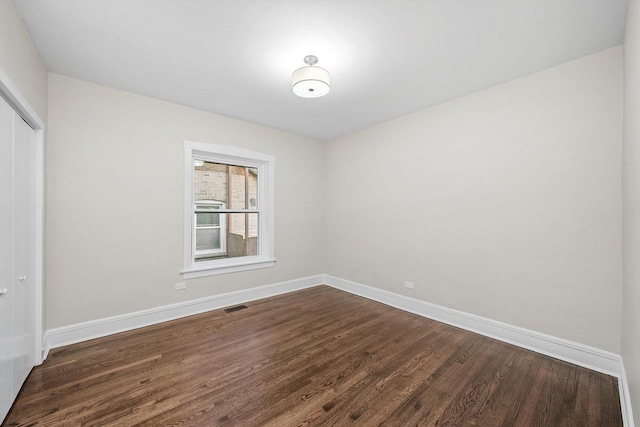 4825 W Oakdale Ave, Chicago, IL 60641 - spare room featuring baseboards and dark wood-style floors