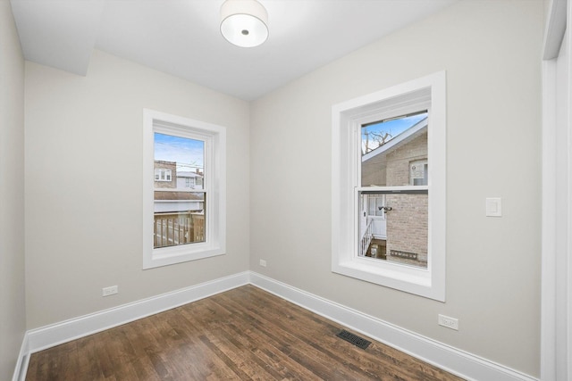4825 W Oakdale Ave, Chicago, IL 60641 - empty room featuring healthy amount of natural light, baseboards, and dark wood-style flooring