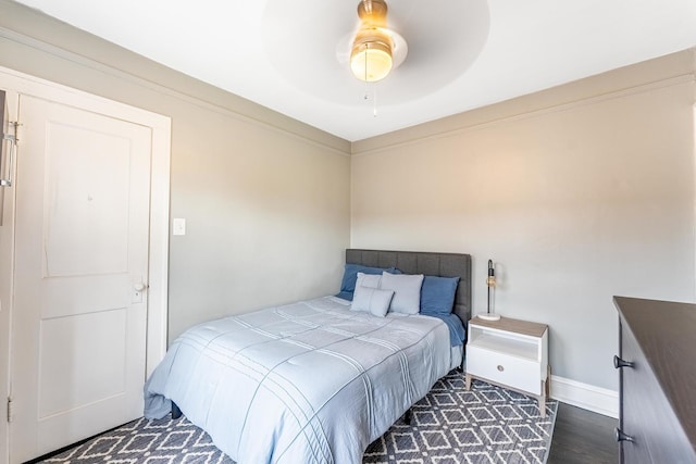 bedroom with a ceiling fan, baseboards, and wood finished floors