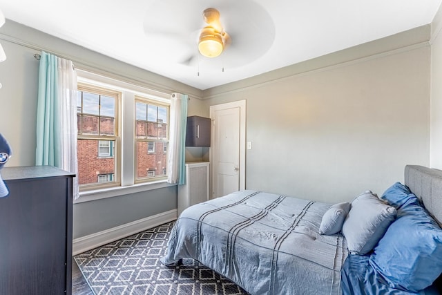 bedroom with dark wood-style flooring, baseboards, and a ceiling fan