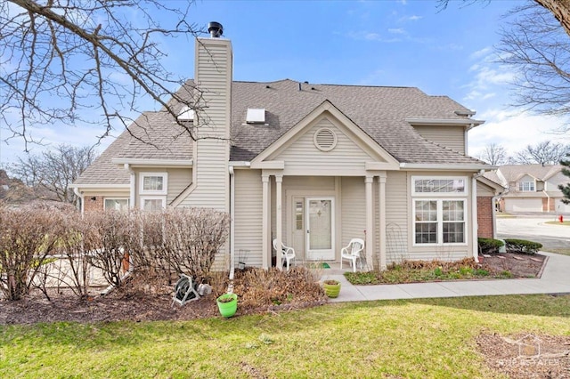 view of front of property featuring a chimney, roof with shingles, and a front lawn