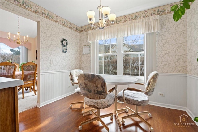 dining room featuring an inviting chandelier, a wainscoted wall, a healthy amount of sunlight, and hardwood / wood-style flooring