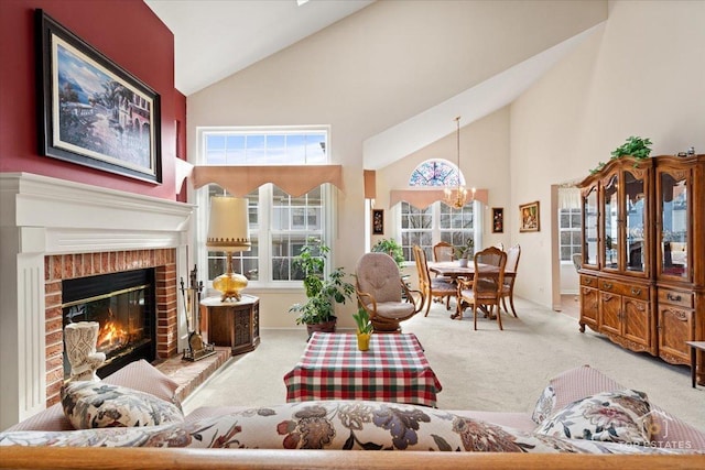 living area with carpet floors, a brick fireplace, a notable chandelier, and high vaulted ceiling