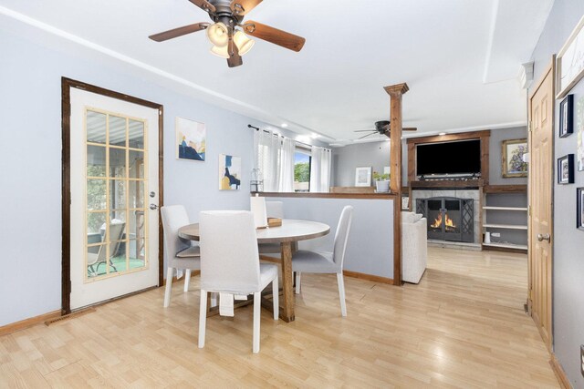 14958 Kildare Ave, Midlothian, IL 60445 - dining area featuring ceiling fan, light wood finished floors, a warm lit fireplace, and baseboards