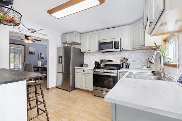 14958 Kildare Ave, Midlothian, IL 60445 - kitchen featuring stainless steel appliances, a sink, backsplash, and light wood-type flooring