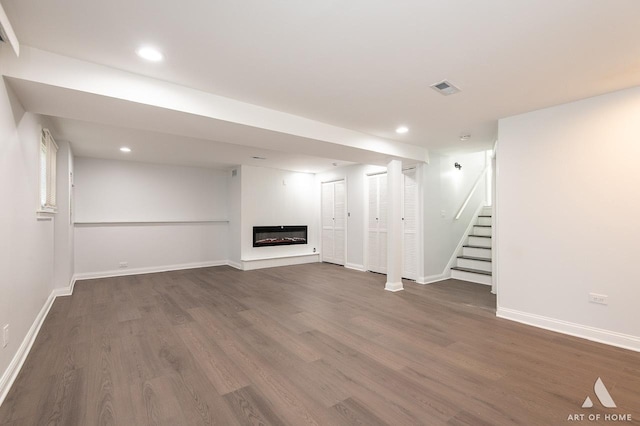 251 N Pleasant Dr, Glenwood, IL 60425 - finished below grade area featuring stairs, visible vents, a glass covered fireplace, and wood finished floors