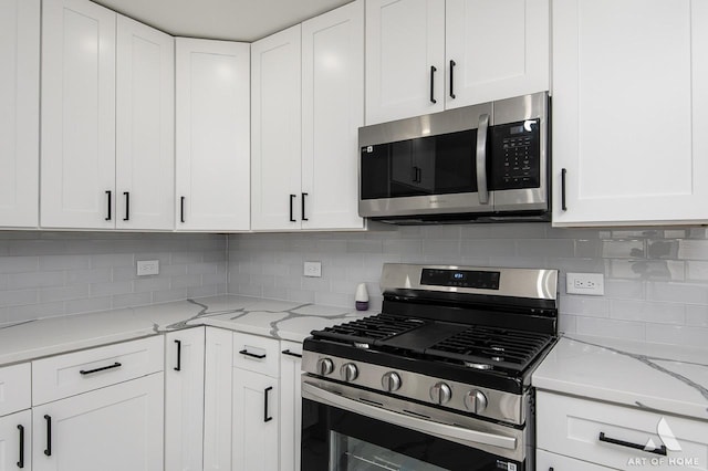251 N Pleasant Dr, Glenwood, IL 60425 - kitchen featuring white cabinets, light stone countertops, appliances with stainless steel finishes, and decorative backsplash