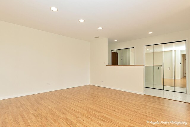 empty room featuring recessed lighting, light wood-style flooring, and baseboards