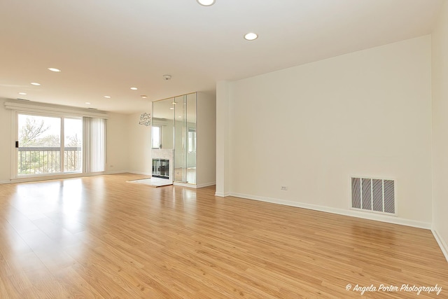 unfurnished living room with baseboards, recessed lighting, light wood-style flooring, and visible vents