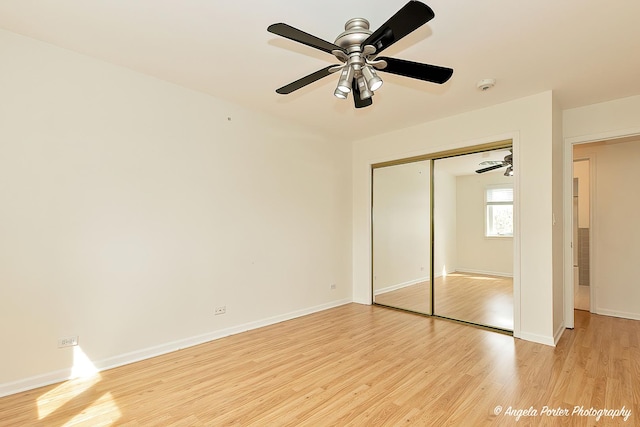 unfurnished bedroom with a closet, baseboards, and light wood-style floors