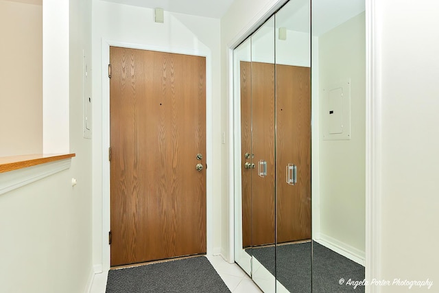 doorway with baseboards and light tile patterned floors
