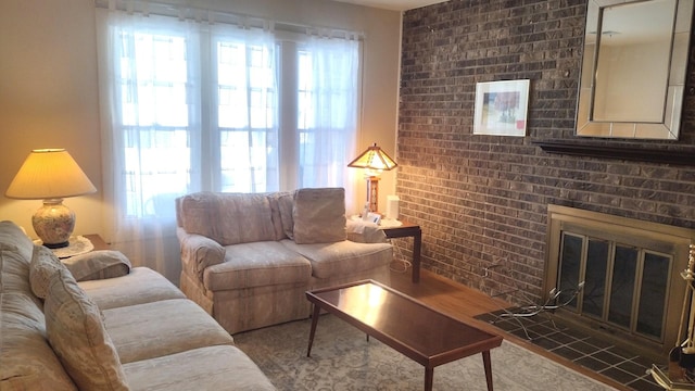 living room with baseboards, a brick fireplace, and wood finished floors