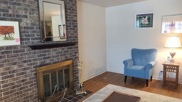 living room with baseboards, wood finished floors, and a fireplace