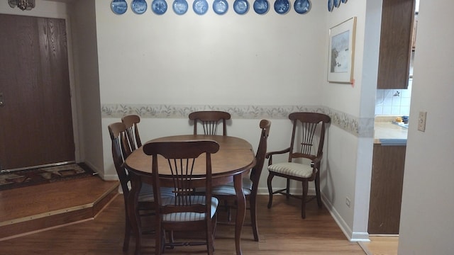 dining space with baseboards and dark wood-style flooring