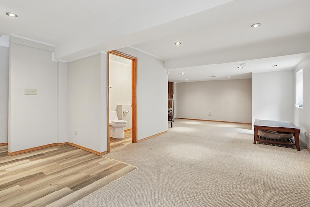 below grade area featuring recessed lighting, baseboards, and light colored carpet
