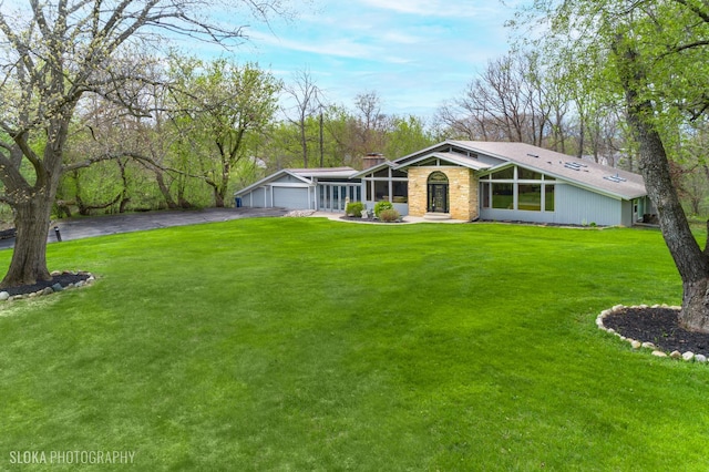 184A River Rd, Lake Barrington, IL 60010 - view of front of property with a chimney, asphalt driveway, a front lawn, stone siding, and an attached garage