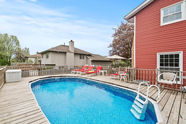 view of swimming pool featuring a fenced in pool, fence, and a wooden deck
