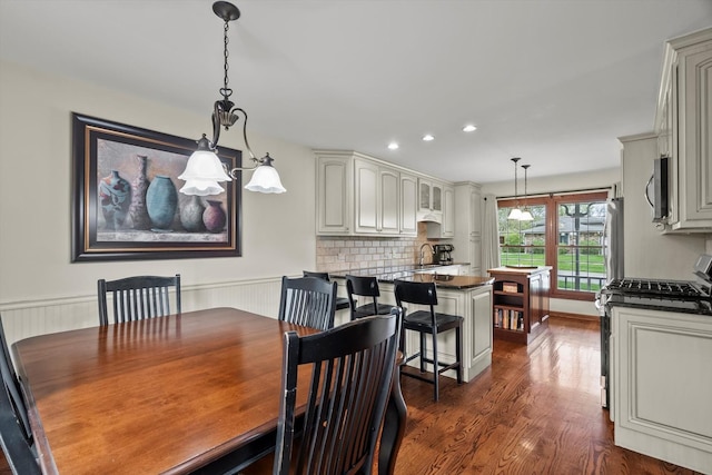 dining area with recessed lighting, a wainscoted wall, and dark wood-style floors