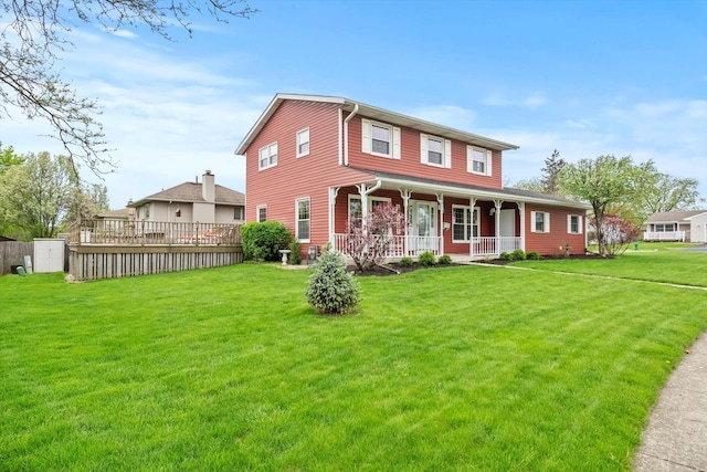 view of front facade featuring fence, covered porch, and a front yard
