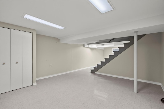 finished below grade area with stairs, baseboards, and light floors