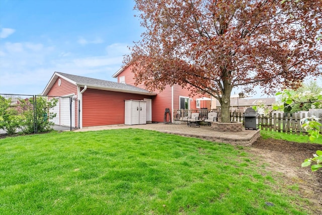 back of house featuring a patio, a fenced backyard, a yard, and an outdoor structure