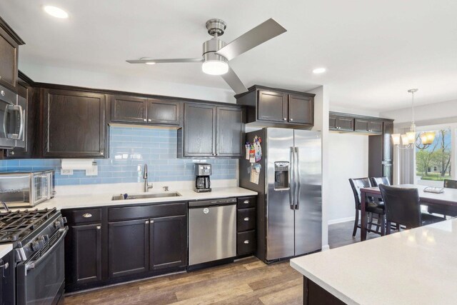 1046 Piccolo Ln, Volo, IL 60073 - kitchen with stainless steel appliances, a sink, dark brown cabinetry, a chandelier, and a ceiling fan