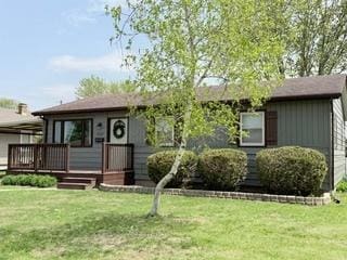 single story home featuring a wooden deck and a front yard