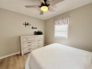 bedroom with baseboards, a ceiling fan, and wood finished floors
