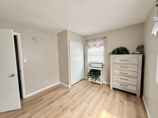 bedroom featuring baseboards and light wood finished floors