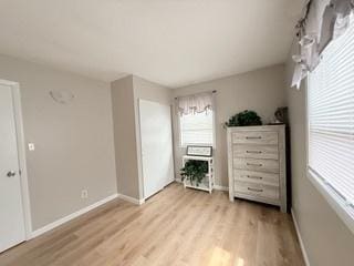 unfurnished bedroom with baseboards and light wood-style flooring