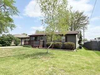back of house featuring a lawn and a wooden deck