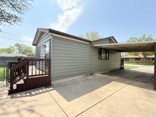 view of property exterior with a carport and driveway