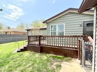 back of property featuring a fenced backyard, a yard, and a deck