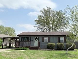 ranch-style house with a front yard and an attached carport