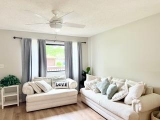 living area featuring a ceiling fan and wood finished floors