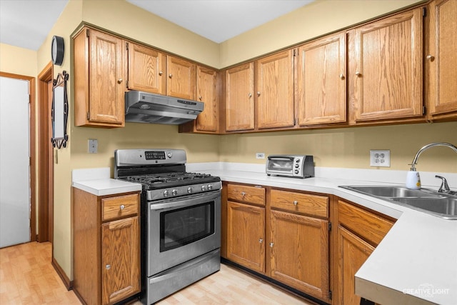 1081 Hunt Wyck Ct Unit 1081, Elgin, IL 60120 - kitchen with under cabinet range hood, stainless steel range with gas stovetop, a sink, and light wood finished floors