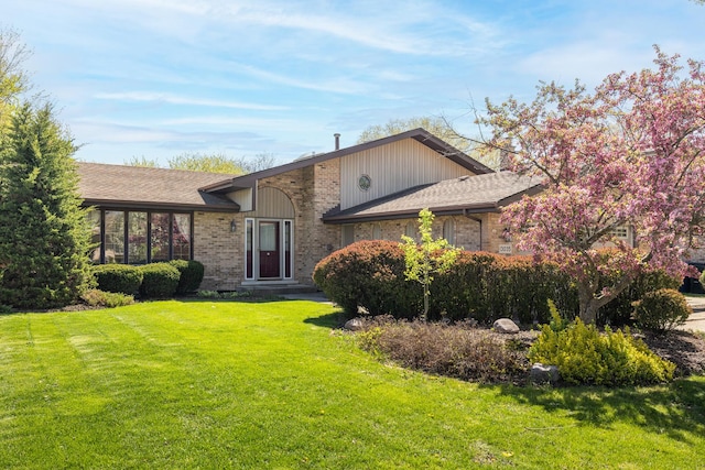 view of front of house featuring brick siding and a front lawn